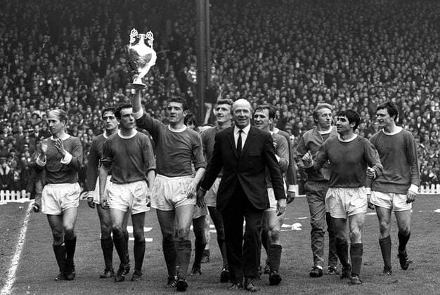 Bill Foulkes (Mitte) mit dem Meisterpokal, außerdem u.a.: Bobby Charlton (li.), John Aston (3.v.li.), Trainer Matt Busby, Dennis Law (3.v.re.), Tony Dunne (2.v.re.) und James Ryan (alle Manchester United, re.) - Fußball Herren English First Division 1966 1967, 1. Englische Liga, Manchester United, ManU Totale Manchester Freude,