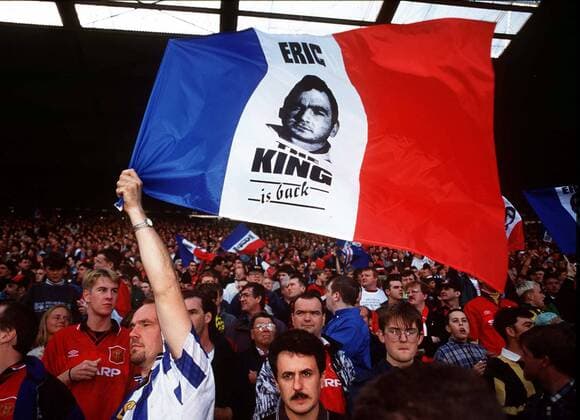 Manchester United Fans feiern die Rückkehr von Eric Cantona, der nach einer mehrmonatigen Sperre wieder auflaufen darf: Eric the King is back -  Fußball Herren English Premier League 1995 1996, Manchester United, ManU, Vneg Gruppe Manchester