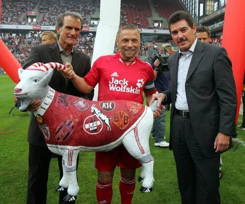 Präsident Wolfgang Overath (li.) und Vizepräsident Jürgen Glowacz (1. FC Köln) überreichen Thomas Häßler (Köln Allstars) eine Nachbildung des Maskottchen Hennes VII mit den Emblemen seiner ehemaligen Vereine Fußball Herren Thomas Häßlers Abschiedsspiel 2005, Abschied, Red Bull Salzburg, Reinickendorfer Füchse, Vdig Gruppe o0 Verabschiedung, verabschieden, Karriereende Köln