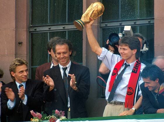 Siegesfeier auf dem Frankfurter Rathausbalkon, v.li.: Thomas Häßler, Teamchef Franz Beckenbauer, Andreas Möller mit dem FIFA Weltpokal und Schal von Eintracht Frankfurt sowie Pierre Littbarski (alle BR Deutschland) Fußball 1. BL Herren WM 1990, Nationalmannschaft, BRD, Empfang, Ankunft, Feier, Schal, Schals, Fanschals Gruppe Frankfurter Römer, Rathausplatz, Rathaus, Balkon Frankfurt M. Glück, Harmonie, Freude, Fußball 1. BL Herren WM 1990, Nationalmannschaft, BRD, Empfang, Ankunft, Feier, Schal, Schals, Fanschals Gruppe Frankfurter Römer, Rathausplatz, Rathaus, Balkon Frankfurt M. Glück, Harmonie, Freude,