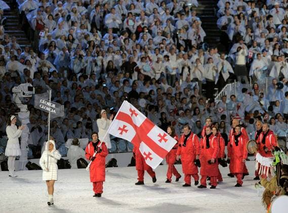 12 02 2010-Vancouver: Olympische Spiele 2010 Eroeffnungsveranstaltung im BC Place Einlauf der Mannschaft aus Georgien mit Fahnenträger Isaon Abramashvili im Trauerflor nach dem Tod seines Mannschaftskollegen, des Rodlers Nodar Kumaritashvili o0 Olympiateam Fahnenträger Fahne, Nationalfahne Totale
