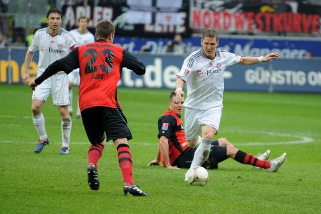 20.03.2010, Eintracht Frankfurt - FC Bayern München, v.li.: Mark van Bommel (Bayern), Marco Russ (Eintracht), Bastian Schweinsteiger (Bayern), am Boden Alexander Meier (Eintracht)