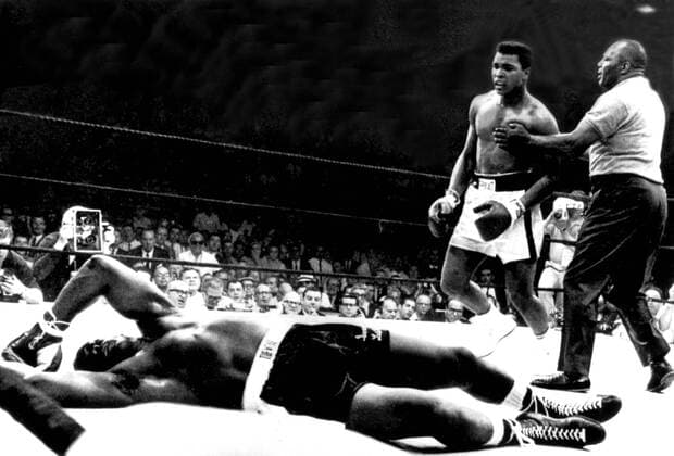 Referee Joe Walcott restrains World Heavyweight Champion Cassius Clay as challenger Sonny Liston rolls on the canvas. Clay knocked out Liston in the first round to retain his title in Lewiston, Maine, USA. 25th May 1965.  UnitedArchives00563623