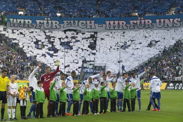 Die Mannschaft von GE bei der Aufstellung. Im Hintergrund zeigen die Fans ein Banner mit der Aufschrift >Wir für Euch - Ihr für uns<. Fussball 1. Bundesliga, 3. Spieltag, Borussia Mönchengladbach (MG) - FC Schalke 04 (GE), 4:1, am 13.09.2014 in Mönchengladbach Deutschland. Â