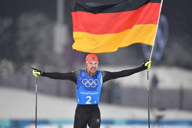 Final runner Johannes RYDZEK GER races to the finish line with the German flag Cheers Joy Enthusiasm Action Olympic champion Olympic champion Team photo Team Team photo Nordic Combined Team Gundersen LH 4x5 km Nordic Combined Teamshift Alpensia Ski Cross Center 2018 Winter Olympics from 09 02 25 02 2018 in PyeongChang South Korea
