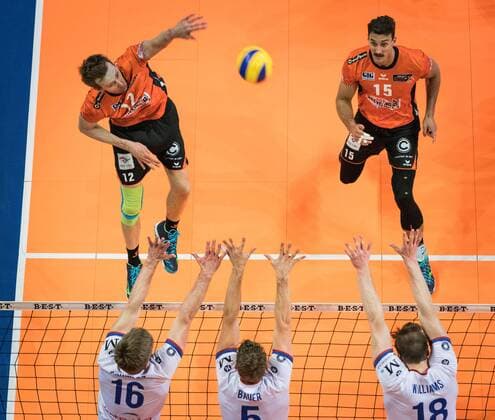 Berlin Germany 14 04 2018 Paul Carroll BR Volleys 12 against the block from Sebastian Schwarz RheinMain Volleys 16 Lukas Bauer RheinMain Volleys 5 and Lincoln Alexander Williams RheinMain Volleys 18 at the Play Off Semifinals Game 1 of the Volleyball Bundesliga between Berlin Recycling Volleys and United Volleys Rhein Main
