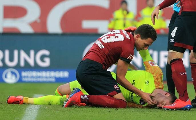 02 02 2019 1 BL 1 FC Nuernberg vs Werder Bremen Max Morlock Stadium Nuernberg Football Sport in picture Moment of shock Christian Mathenia 1 FC Nuernberg lies on the ground KO after a collision with Theodor Gebre Selassie Bremen Georg Margreitter 1 FC Nuernberg pulls out his tongue DFL REGULATIONS PROHIBIT ANY USE OF PHOTOGRAPHS AS IMAGE SEQUENCES AND OR QUASI VIDEO