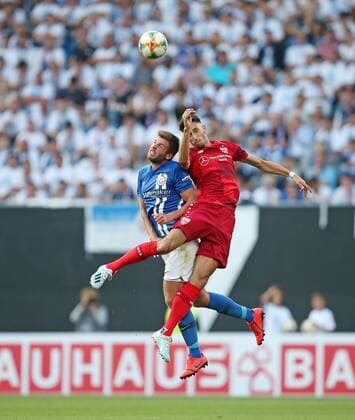 Rostock , Soccer DFB Cup 1 Round , Hansa Rostock vs. VfB Stuttgart , L R Marco Königs Hansa Rostock , Atakan Karazor Stuttgart DFB REGULATIONS PROHIBIT ANY USE OF PHOTOGRAPHS AS IMAGE SEQUENCES AND OR QUASI VIDEO According to the regulations of the DFB German Football Association it is forbidden to use photographs taken in the stadium and or during the match in the form of sequence pictures and or video-like photo sequences or to have them used.