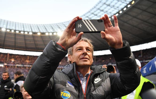 Jürgen Klinsmann trainer Hertha BSC , is besieged by the photographers shortly before the start of the game, while he is shooting his own clip Hertha BSC Berlin BVB Borussia Dortmund 1 Bundesliga 2019 2020, 1 BL with his smartphone, 1 Bundesliga, DFL, Football, Soccer, Soccer, Men, Men, Men, Germany, Germany Berlin, 30 11 2019, Olympiastadion DFL REGULATIONS PROHIBIT ANY USE OF PHOTOGRAPHS AS IMAGE SEQUENCES AND OR QUASI VIDEO