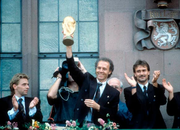 Reception of the 1990 World Champions at Frankfurts Römerberg 09 07 1990 National Coach Franz Beckenbauer with the World Cup, left Thomas Häßler , right TW Raimond Aumann HM