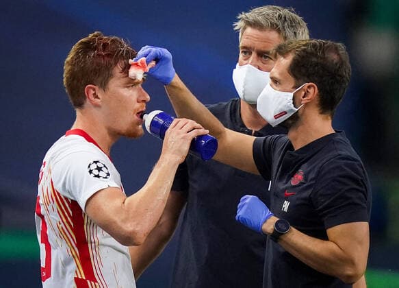 RB LEIPZIG ATLETICO MADRID, Football UEFA Champions League Lisbon, Portugal, 13th August 2020, Marcel Halstenberg RBL bleeds after clash with Stefan Savic Atletico and is treated in the quarterfinal UEFA Champions League match final tournament RB LEIPZIG ATLETICO MADRID in Season 2019 2020 Photographer Peter Schatz Pool UEFA REGULATIONS PROHIBIT ANY USE OF PHOTOGRAPHS as IMAGE SEQUENCES and or QUASI VIDEO National and international News Agencies OUT Editorial Use ONLY Lisbon Portugal Poolfoto Peter Schatz Pool ,EDITORIAL USE ONLY