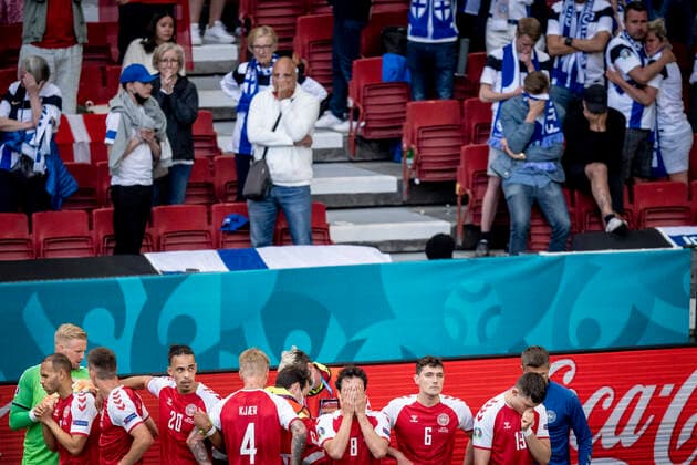 Denmarks Christian Eriksen receives treatment while Danish players screen for him and while fans watch in the background during the match between Denmark and Finland in group B during EURO2020 in the Park in Copenhagen, Saturday 12 June 2021, Copenhagen Denmark  Copyright: RitzauxScanpix MadsxClausxRasmussenx cop101 spdk20210612-200514-L