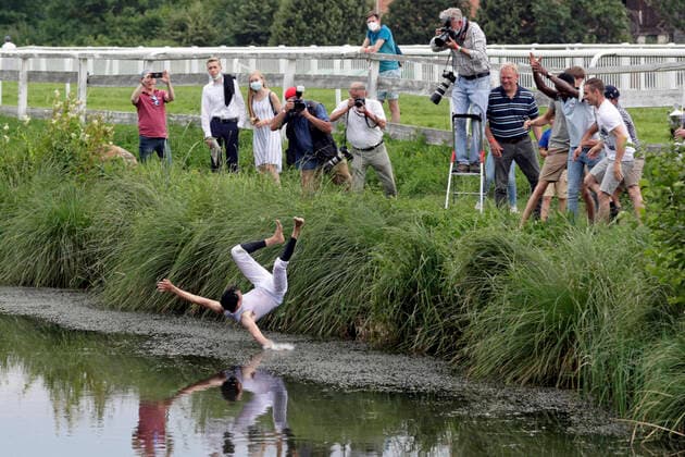 24 07 2021, Bad Harzburg, Lower Saxony, GER Meetings Champion Bauyrzhan Murzabayev is thrown by his colleagues traditionally into the lake racecourse Bad Harzburg, Weisser Stein jockey, jockey champion, meeting champion, Murzabayev, throw, lake, flight phase 210724SG968BAD HARZBURG JPG