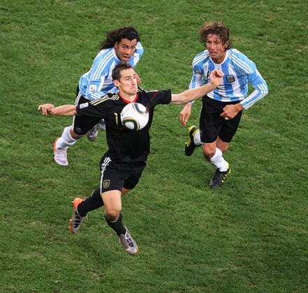 Argentinien gegen Deutschland 03 07 2010 Weltmeisterschaft Argentinien gegen Deutschland Miroslav Klose kontrolliert den Ball auf seiner Brust, beobachtet von den großäugigen Carlos Tevez und Gabriel Heinze Foto Mark Leech Kapstadt Westkap Südafrika  Copyright: xMarkxLeechxOffside al