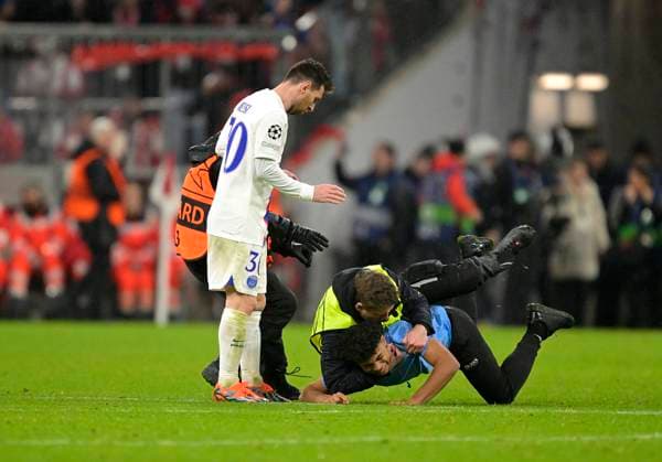 08 03 2023, Football UEFA Champions League 2022 2023 Round of 16 second leg, FC Bayern Munich Paris St Germain, at Allianz Arena Munich stewards wrestle down a young streaker who wants to run to Lionel Messi Paris Saint Germain