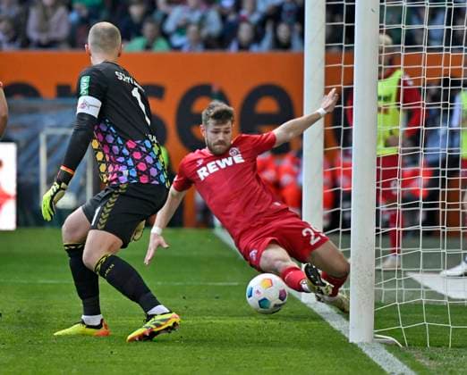 31 03 2024, Soccer 1 Bundesliga 2023 2024, Matchday 27, FC Augsburg 1 FC Köln, in the WWK Arena Augsburg, Jan Thielmann Köln scrapes the ball away from the line f l Goalkeeper Marvin Schwäbe Köln and Jan Thielmann Köln DFL and DFB regulations prohibit any use of photographs as image sequences and or quasi video