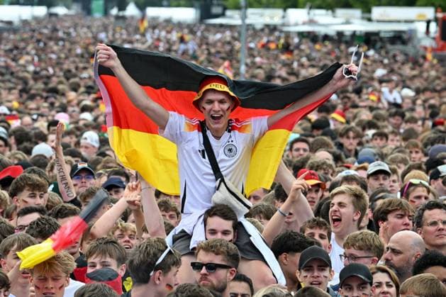 Berlin, Germany July 5, 2024 European Football Championship 2024 Quarterfinal Spain vs. Germany In the picture Cheering fans in the fan zone Brandenburger Tor, a male fan laughing and waving a German flag Germany flag Copyright: xFotostandx xReuhlx