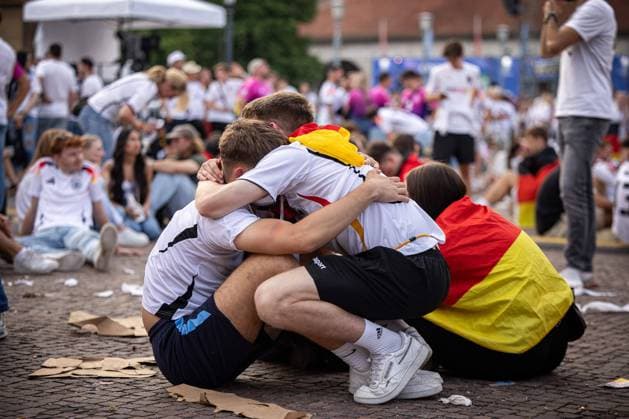 Two Germany fans sit dejected on the ground and hug each other Fans of the German national team lie in tears after the match against Spain and the elimination from the EURO2024 at the fan festival with public viewing on Stuttgarts Schlossplatz, EURO2024 Fanfest Schlossplatz, 05 07 2024 Stuttgart Copyright: xDennisxDuddek xEibnerxPressefotox EP_DDK