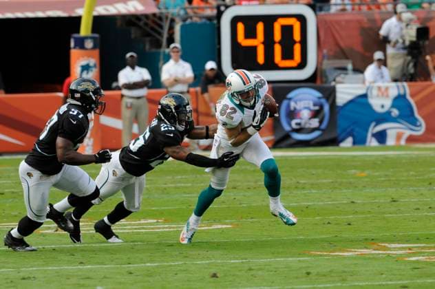 NFL, American Football Herren, USA Jaguars vs Dolphins DEC 16 December 16, 2012: Brian Hartline 82 of the Miami Dolphins tries to avoid the tackle by Dwight Lowery 25 of the Jacksonville Jaguars during the NFL football game between the Miami Dolphins and Jacksonville Jaguars at Sun Life Stadium in Miami Gardens FL. The Dolphins defeated the Jaguars 24-3. Miami Gardens FL U.S. EDITORIAL USE ONLY Copyright: xx ZUMA-20121216_zaf_cd5_106.jpg JCxRidleyx csmphoto689221