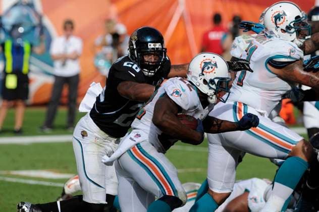 NFL, American Football Herren, USA Jaguars vs Dolphins DEC 16 December 16, 2012: Reggie Bush 22 of the Miami Dolphins tries to avoid the tackle by Dawan Landry 26 of the Jacksonville Jaguars during the NFL football game between the Miami Dolphins and Jacksonville Jaguars at Sun Life Stadium in Miami Gardens FL. The Dolphins defeated the Jaguars 24-3. Miami Gardens FL U.S. EDITORIAL USE ONLY Copyright: xx ZUMA-20121216_zaf_cd5_103.jpg JCxRidleyx csmphoto689224