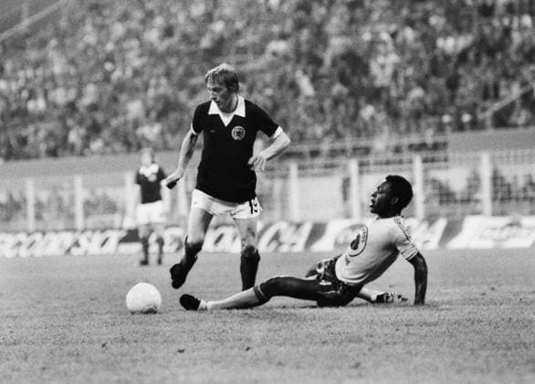 Football - 1974 World Cup - First Round, Group Two: Scotland 2 Zaire 0 Scotland s Denis Law evades a tackle from Zaire s Buanga Tshimen at Westfalenstadion, Dortmund, West Germany.