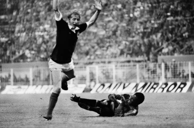 Football - 1974 World Cup - First Round, Group Two: Scotland 2 Zaire 0 Scotland s Denis Law jumps over Zaire goalkeeper Kazadi Muamba at Westfalenstadion, Dortmund, West Germany.