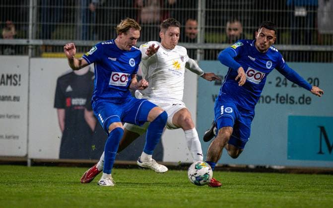 Soccer, Season 2024 2025, Regionalliga West, 11 04 2025, Matchday 29, Men, 1 FC Bocholt white vs VfL Sportfreunde Lotte blue v l Jan Wellers VfL Sportfreunde Lotte , Marko Stojanovic 1 FC Bocholt , Denis Milic VfL Sportfreunde Lotte , Bocholt Stadion am Huenting Nordrhein Westfalen Germany 250411_fb_1fc-bocholt_sf-lotte_39868