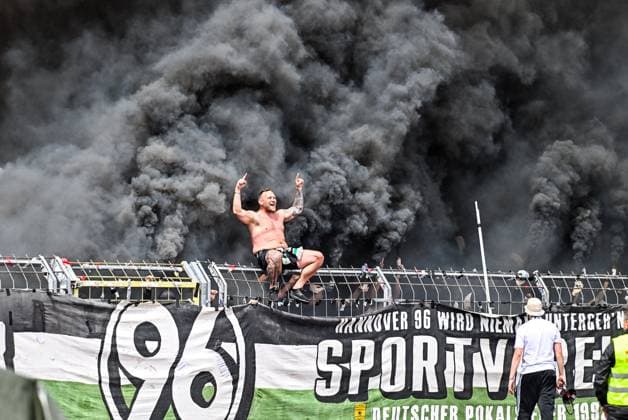 GER, 2 BL, SSV Ulm 1846 vs Hannover 96 03 05 2025, Donaustadion, Ulm, GER, 2 BL, SSV Ulm 1846 vs Hannover 96, in the picture Ultra from Hannover sits on the fence, behind him clouds of smoke from pyrotechnics and Bengalos are drifting nordphotoxGmbHx xHafner nph00200