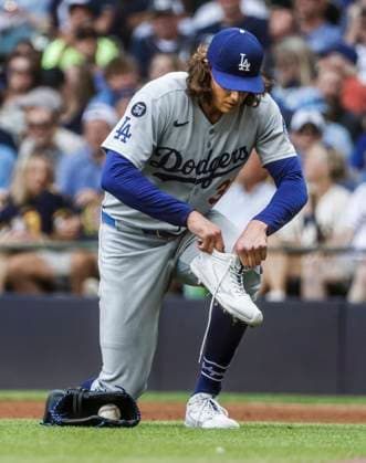 Los Angeles Dodgers starting pitcher Tyler Glasnow puts his shoe on after it came off as the covered first base to out Milwaukee Brewers outfielder Isaac Collins in the fifth inning of the MLB, Baseball Herren, USA game between the Los Angeles Dodgers and the Milwaukee Brewers at American Family Field in Milwaukee, Wisconsin, on Wednesday, July 9, 2025. MIL20250709810 TANNENxMAURY