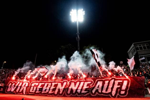 Soccer, Season 2025 2026, 3 Liga, Donaustadion Ulm, 7 Matchday, SSV Ulm 1846 Soccer SSV Jahn Regensburg, 21 09 2025 21 09 2025, Soccer, Season 2025 2026, 3 Liga, Donaustadion Ulm, 7 Matchday, SSV Ulm 1846 Fußball SSV Jahn Regensburg, The fans of SSV Ulm in the fan block home block D block Donaustadion with a banner WIR GEBEN NIE AUF with pyrotechnics pyro photo Lucca Fundel Ulm Donaustadion Baden Württemberg Germany