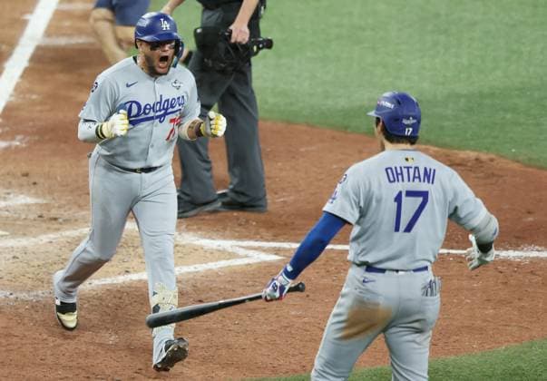 Los Angeles Dodgers Miguel Rojas (72) celebrates with Shohei Ohtani as he scores after hitting a solo home run in the ninth inning against the Toronto Blue Jays during Game Seven of the MLB, Baseball Herren, USA World Series at Rogers Centre in Toronto, Canada, on Saturday, November 1, 2025.  TOR20251101867 AARONxJOSEFCZYK
