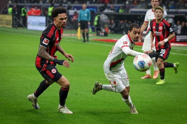 Nnamdi Collins 34 Eintracht Frankfurt , left, in action with Alexis Claude Maurice 20 FC Augsburg , Eintracht Frankfurt vs FC Augsburg, Football, Bundesliga, DFL, Saison 2025 2026, Hinrunde, 14 Spieltag, 13 12 2025 DFB regulations prohibit any use of photographs as image sequences and or quasi video Frankfurt Hessen Germany Copyright: xkolbert-press MartinxAgüerax