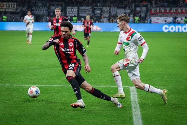 Nnamdi Collins 34 Eintracht Frankfurt , left, in duel with Anton Kade 30 FC Augsburg , Eintracht Frankfurt vs FC Augsburg, Football, Bundesliga, DFL, Saison 2025 2026, Hinrunde, 14 Spieltag, 13 12 2025 DFB regulations prohibit any use of photographs as image sequences and or quasi video Frankfurt Hessen Germany Copyright: xkolbert-press MartinxAgüerax