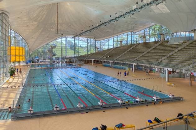 Olympia-Schwimmhalle München - Innenraum mit 50-m-Becken, Sprungturm und Tribüne, Deutschland Munich, Germany - August 12, 2022: Interior of Olympic swimming hall. View across the 50 m pool with lanes, starting blocks, diving tower and the light-filled glass hall (License=RM) 24374516 Copyright: xZoonar.com FabianxMesebergx 24374516