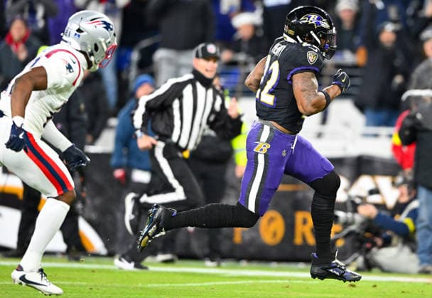 Baltimore Ravens running back Derrick Henry (22) runs past New England Patriots safety Jaylinn Hawkins (21) for a 21-yard touchdown run during the first quarter at M&T Bank Stadium in Baltimore, Maryland, on Sunday, December 21, 2025. BAL20251221111 DAVIDxTULIS