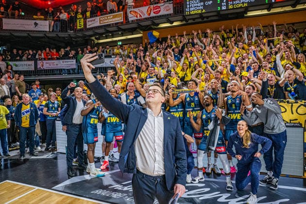 1 Basketball Bundesliga, easyCredit BBL, Season 2025 2026, Men, Main Round, Matchday 13, 29 12 2025, RASTA Vechta EWE Baskets Oldenburg Lazar Spasic Head Coach EWE Baskets Oldenburg at the victory selfie with the team and their fans Vechta RASTA Dome Lower Saxony Germany