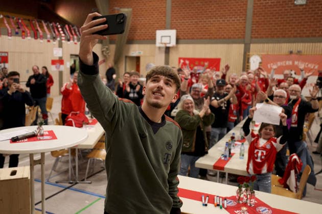 04 01 2026, Soccer, Lennart Karl visits the FC Bayern Munich fan club Burgsinn Lennart Karl FC Bayern Munich takes a photo with the fan club members in the background Burgsinn Sinngrundhalle Bayern Germany