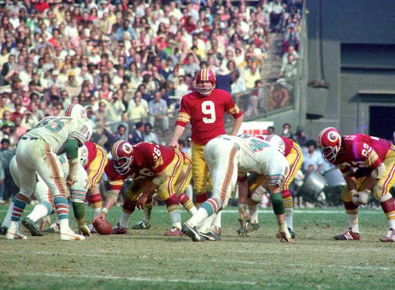 October 13, 1974, Washington, District Of Columbia, USA: Washington Redskins quarterback Sonny Jurgensen 9 calls signals as he prepares to take the snap from center Len Hauss 56 during the game against the Miami Dolphins at RFK Stadium in Washington, DC on October 13, 1974. Also pictured are Dolphins middle linebacker Nick Buoniconti 85 Dolphins right defensive end Bill Stanfill 84, and Redskins left tackle Ray Schoenke 62. The Redskins won the game 20 - 17 Washington USA - ZUMAs152 19741013_faa_s152_004 Copyright: xArniexSachsx Washington USA - ZUMA0846 19741013_faa_s152_004 Copyright: xIMAGO ArniexSachsx