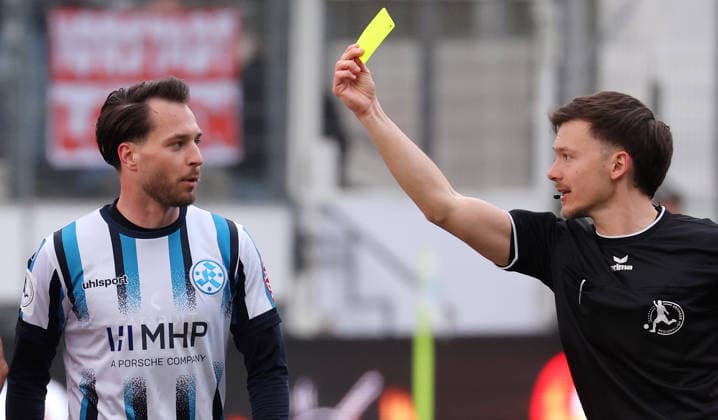 21 03 2026, Germany, Stuttgart, Soccer Regionalliga Südwest, SV Stuttgarter Kickers vs KSV Hessen Kassel, Referee Lukas Jungfleisch shows David Tomic Kickers the yellow card