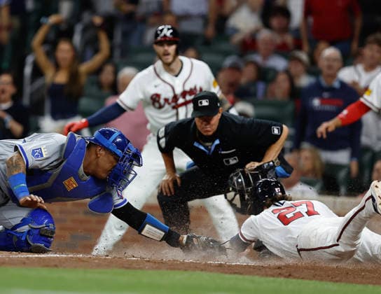 Atlanta Braves third baseman Austin Riley 27 slides into home plate behind the tag of Kansas City Royals catcher Salvador Perez 13 in the seventh inning during the game at Truist Park on Friday, March 27, 2026 in Atlanta, Georgia.  ATL20260327121 MikexZarrilli