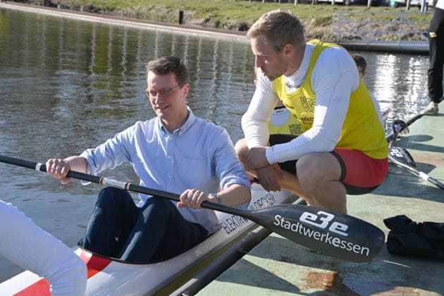 Hendrik WUEST, Wüst, CDU, State Premier of North Rhine-Westphalia, has taken a seat in the Four K kayak, Max RENDSCHMIDT explains the boat and the paddle to him, Hendrik WUEST, Wüst, CDU, State Premier of North Rhine-Westphalia, visits the Duisburg Wedau rowing performance center as part of the campaign for the CologneRhineRuhr bid for the 2036, 2040 and 2044 Olympic and Paralympic Games, 07 04 2026 Â