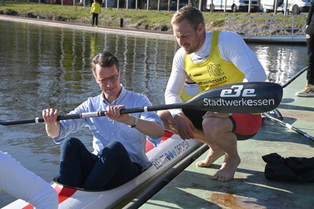 Hendrik WUEST, Wüst, CDU, State Premier of North Rhine-Westphalia, has taken a seat in the Four K kayak, Max RENDSCHMIDT explains the boat and the paddle to him, Hendrik WUEST, Wüst, CDU, State Premier of North Rhine-Westphalia, visits the Duisburg Wedau rowing performance center as part of the campaign for the CologneRhineRuhr bid for the 2036, 2040 and 2044 Olympic and Paralympic Games, 07 04 2026 Â