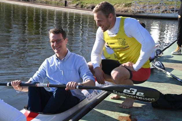 Hendrik WUEST, Wüst, CDU, State Premier of North Rhine-Westphalia, has taken a seat in the Four K kayak, Max RENDSCHMIDT explains the boat and the paddle to him, Hendrik WUEST, Wüst, CDU, State Premier of North Rhine-Westphalia, visits the Duisburg Wedau rowing performance center as part of the campaign for the CologneRhineRuhr bid for the 2036, 2040 and 2044 Olympic and Paralympic Games, 07 04 2026 Â