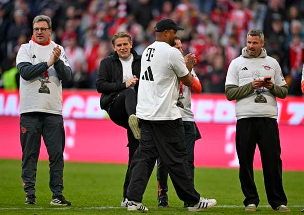 19 04 2026, Soccer Bundesliga 2025 2026, Matchday 30, FC Bayern Munich VfB Stuttgart, in the Allianz Arena Munich, f l x, Sports Director Christoph Freund Bayern Munich , x, Coach Vincent Kompany FC Bayern Munich and x celebrate with Meister Kakadu T Shirt Sports Director Christoph Freund Bayern Munich gives Coach Vincent Kompany FC Bayern Munich a kick DFL and DFB regulations prohibit any use of photographs as image sequences and or quasi video