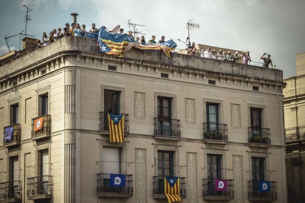 September 23, 2017 - Barcelona, Catalonia, Spain - Pro-independence activists hang their banner from the top of a building during the performance of the Castellers (human towers) during Barcelona s city festival La Merce in support of the planned secession referendum at October1st. Spain s constitutional court has suspended the Catalan referendum law after the Central Government has challenged it in the Courts. Copyright: xMatthiasxOesterlex