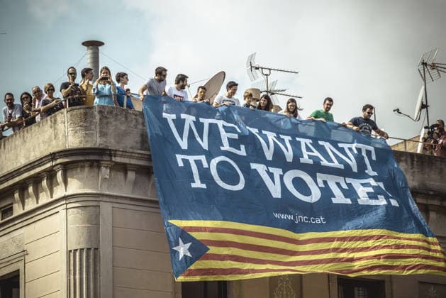 September 23, 2017 - Barcelona, Catalonia, Spain - Pro-independence activists hang their banner from the top of a building during the performance of the Castellers (human towers) during Barcelona s city festival La Merce in support of the planned secession referendum at October1st. Spain s constitutional court has suspended the Catalan referendum law after the Central Government has challenged it in the Courts. Copyright: xMatthiasxOesterlex