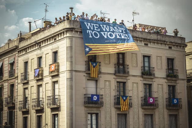 September 23, 2017 - Barcelona, Catalonia, Spain - Pro-independence activists hang their banner from the top of a building during the performance of the Castellers (human towers) during Barcelona s city festival La Merce in support of the planned secession referendum at October1st. Spain s constitutional court has suspended the Catalan referendum law after the Central Government has challenged it in the Courts. Copyright: xMatthiasxOesterlex