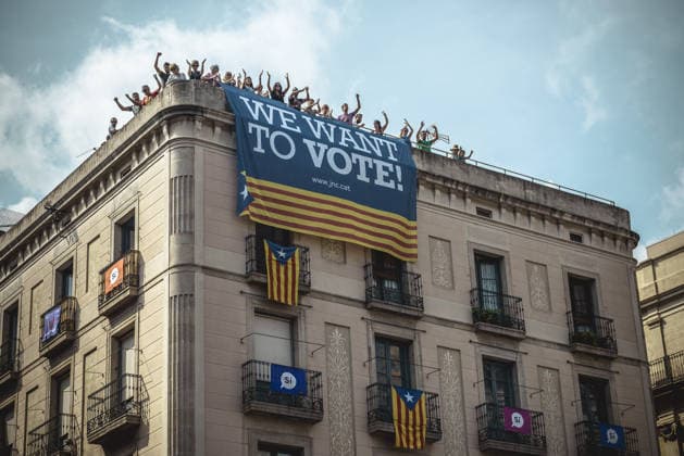 September 23, 2017 - Barcelona, Catalonia, Spain - Pro-independence activists hang their banner from the top of a building during the performance of the Castellers (human towers) during Barcelona s city festival La Merce in support of the planned secession referendum at October1st. Spain s constitutional court has suspended the Catalan referendum law after the Central Government has challenged it in the Courts. Copyright: xMatthiasxOesterlex