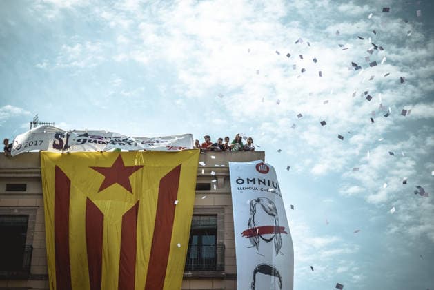 September 24, 2017 - Barcelona, Catalonia, Spain - Pro-independence activists hang a giant Estelada flag from the top of a building and throw ballot papers during the performance of the Castellers (human towers) during Barcelona s city festival La Merce in support of the planned secession referendum at October1st. Spain s constitutional court has suspended the Catalan referendum law after the Central Government has challenged it in the Courts Copyright: xMatthiasxOesterlex