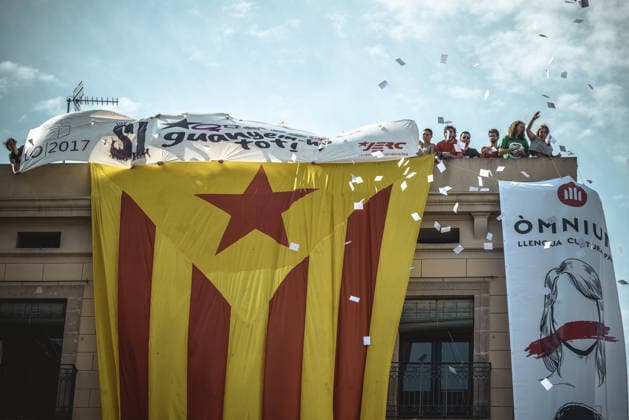 September 24, 2017 - Barcelona, Catalonia, Spain - Pro-independence activists hang a giant Estelada flag from the top of a building and throw ballot papers during the performance of the Castellers (human towers) during Barcelona s city festival La Merce in support of the planned secession referendum at October1st. Spain s constitutional court has suspended the Catalan referendum law after the Central Government has challenged it in the Courts Copyright: xMatthiasxOesterlex